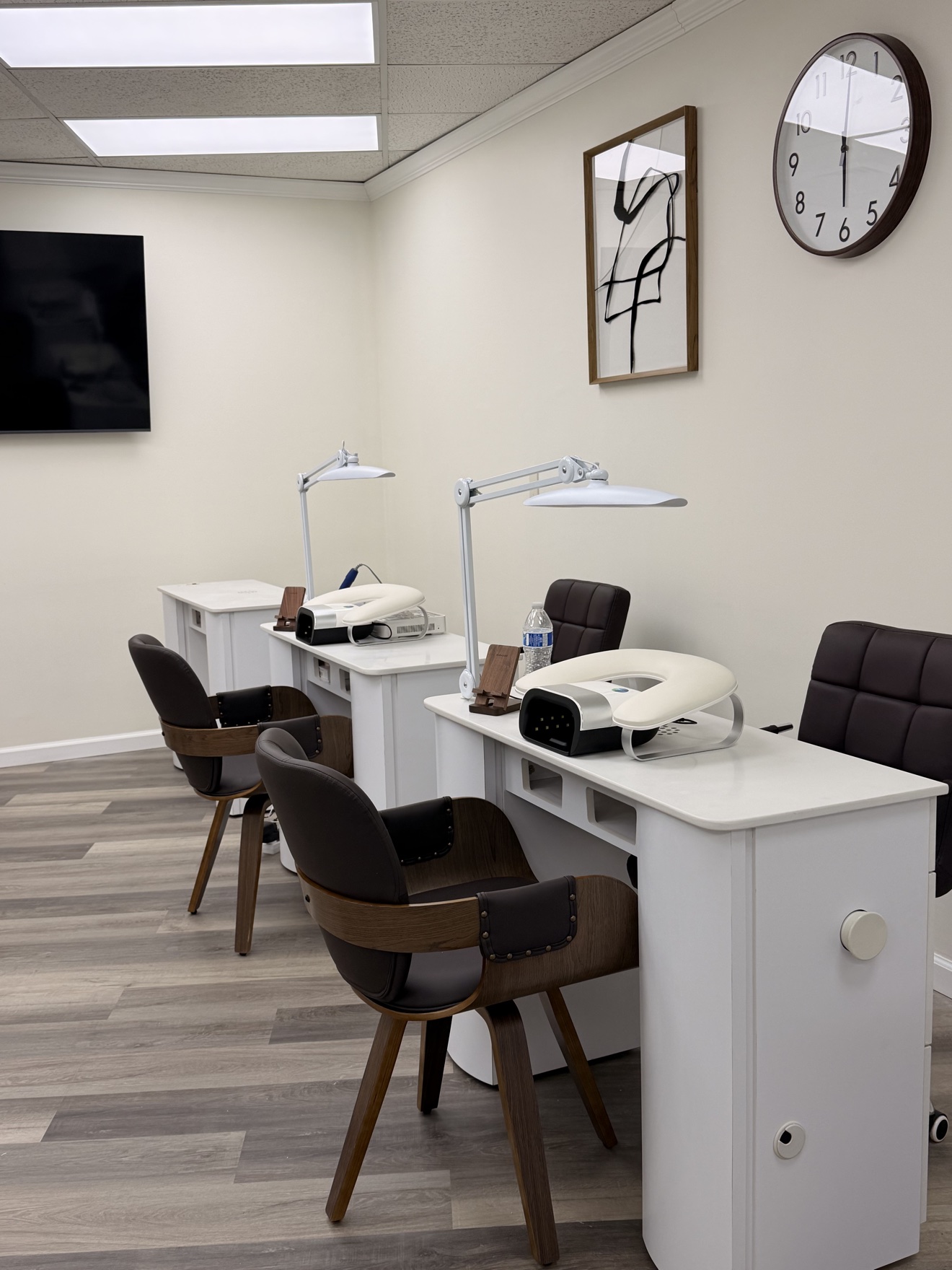 Inside MK Nail Studio — white manicure tables with task lamps and client chairs